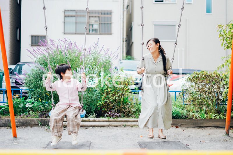 お母さんとブランコに乗る男の子