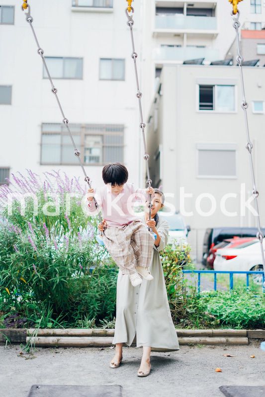 お母さんとブランコに乗る男の子