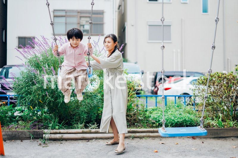 お母さんとブランコに乗る男の子