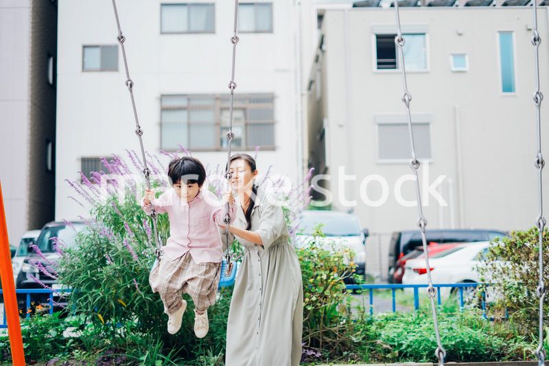 お母さんとブランコに乗る男の子
