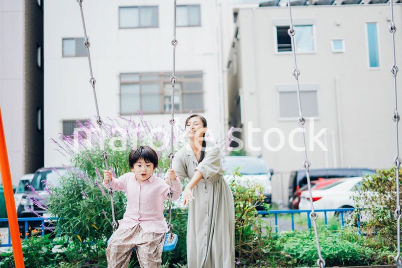 お母さんとブランコに乗る男の子