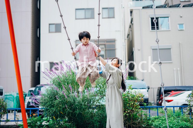 お母さんとブランコに乗る男の子
