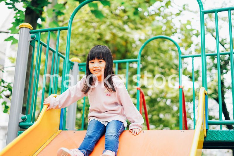 滑り台で遊ぶ小さな女の子