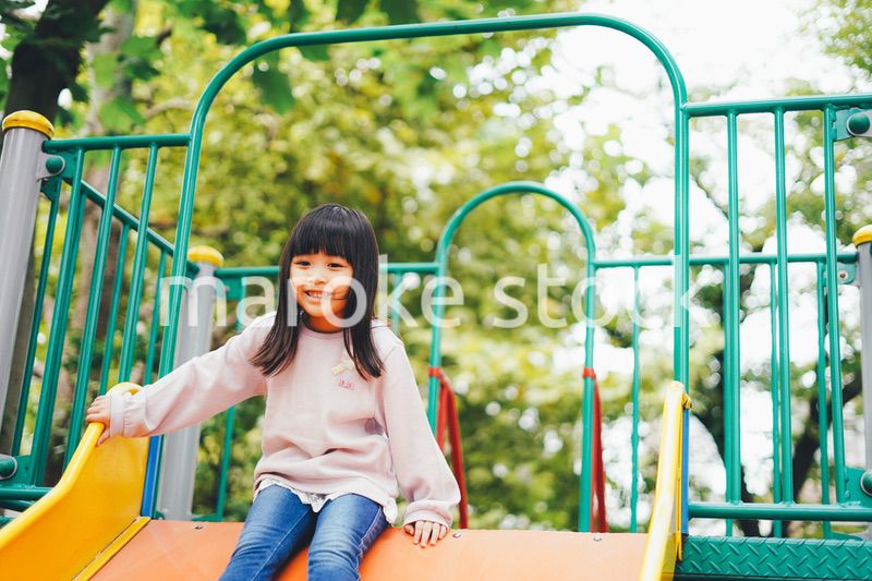 滑り台で遊ぶ小さな女の子