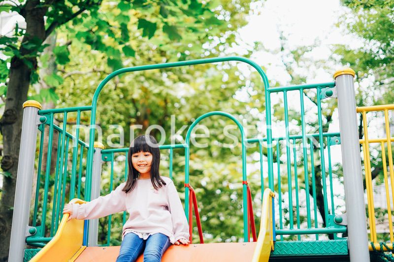 滑り台で遊ぶ小さな女の子