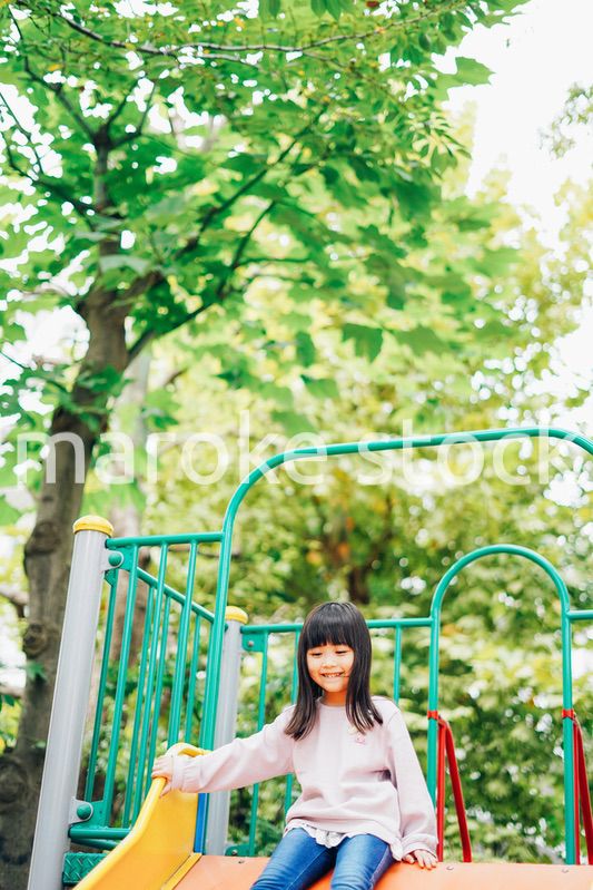 滑り台で遊ぶ小さな女の子