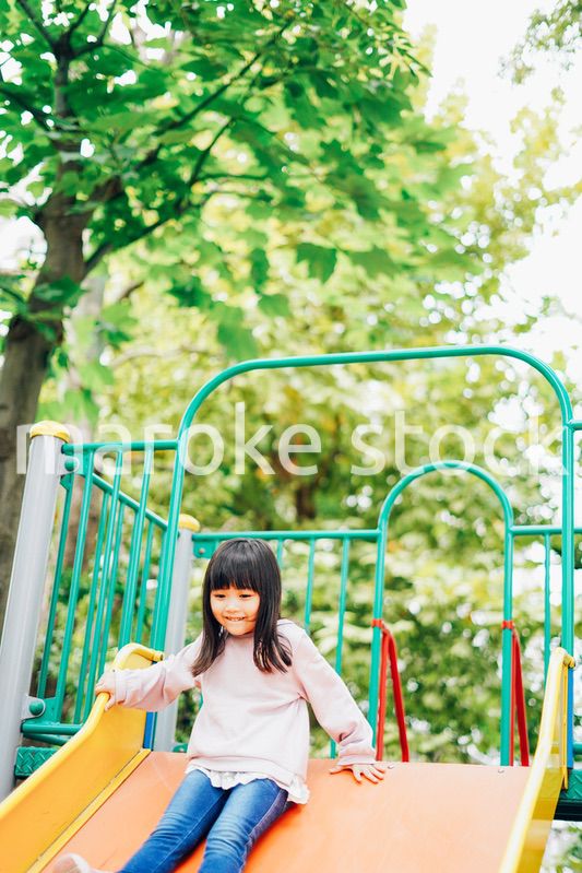 滑り台で遊ぶ小さな女の子