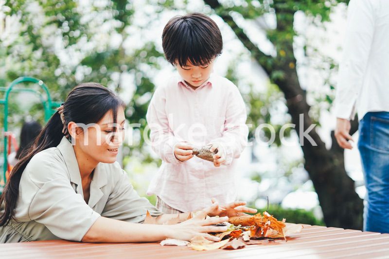 葉っぱで遊ぶお母さんと息子