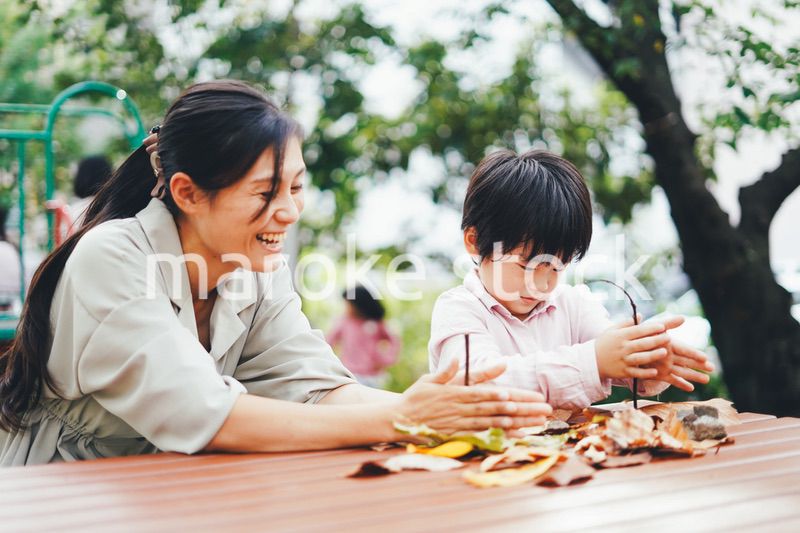 葉っぱで遊ぶお母さんと息子