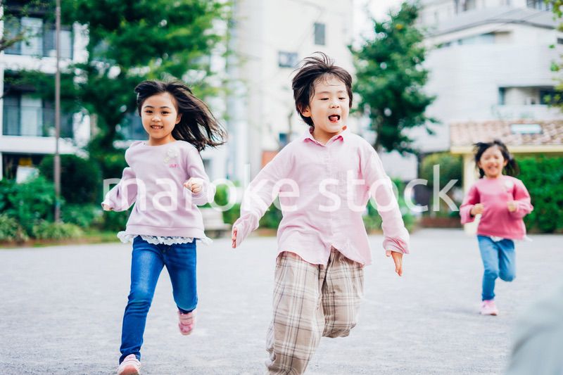 公園でかけっこをする小さな子どもたち