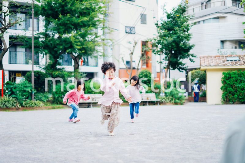 公園でかけっこをする小さな子どもたち