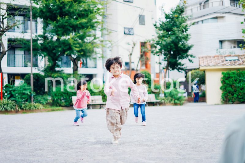 公園でかけっこをする小さな子どもたち