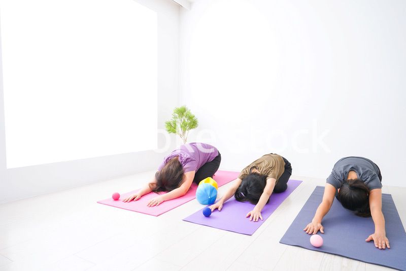 室内でヨガをする女性たち