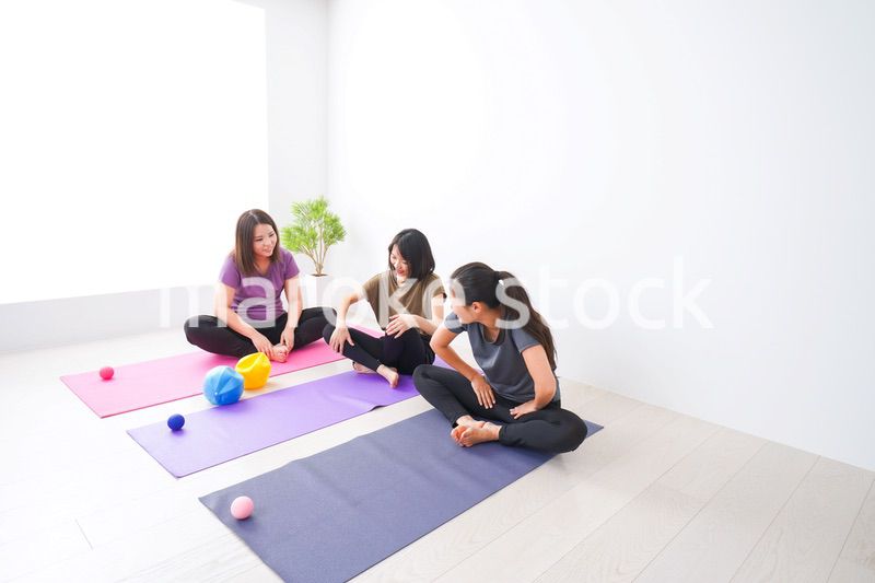 室内でヨガをする女性たち