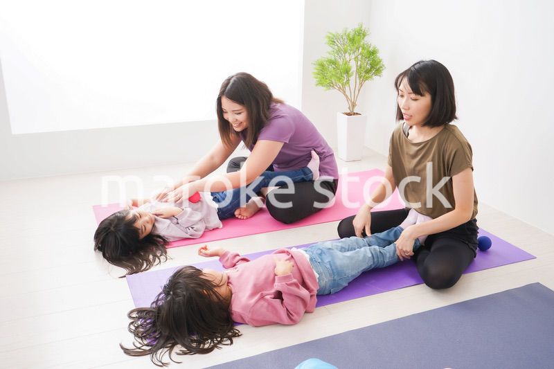 室内でヨガをする子供とお母さん