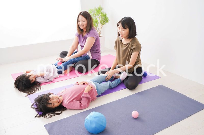 室内でヨガをする子供とお母さん