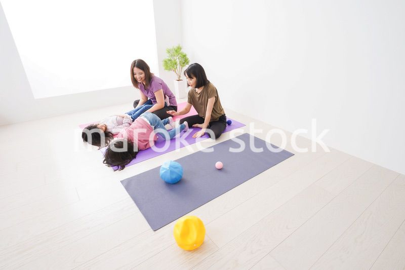 室内でヨガをする子供とお母さん