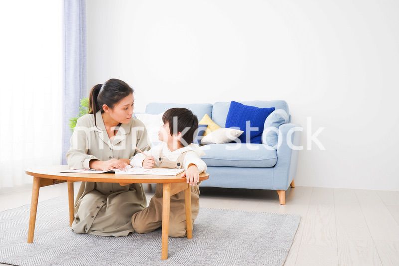 家でお母さんと一緒に勉強をする男の子