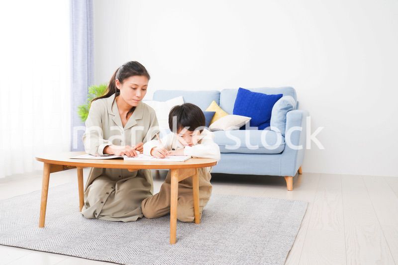 家でお母さんと一緒に勉強をする男の子