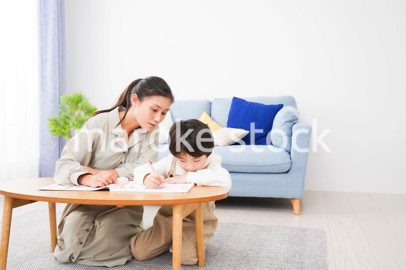 家でお母さんと一緒に勉強をする男の子