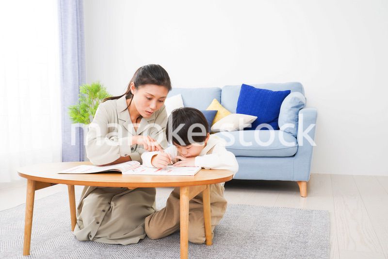 家でお母さんと一緒に勉強をする男の子