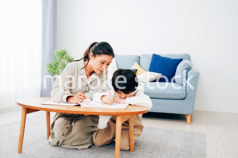 家でお母さんと一緒に勉強をする男の子