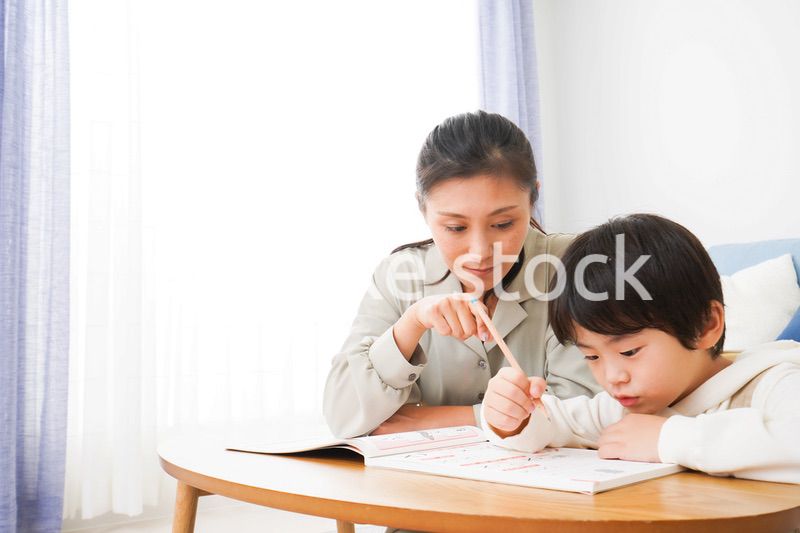 家でお母さんと一緒に勉強をする男の子