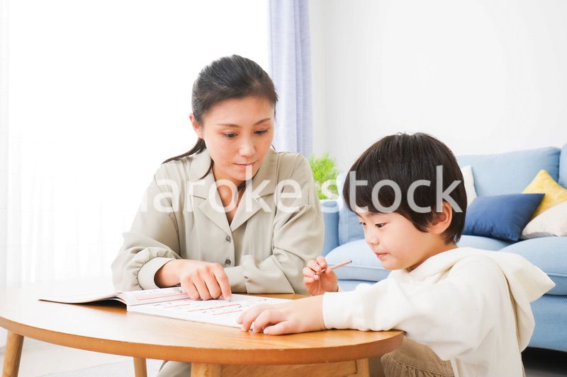 家でお母さんと一緒に勉強をする男の子