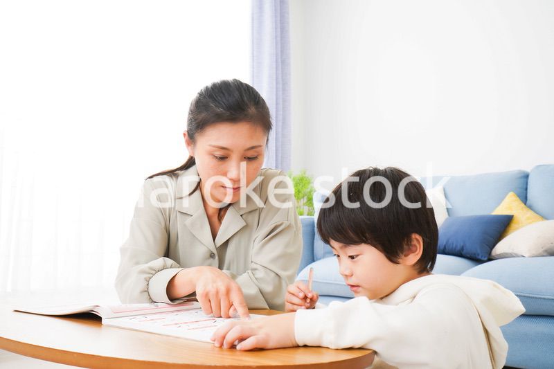 家でお母さんと一緒に勉強をする男の子