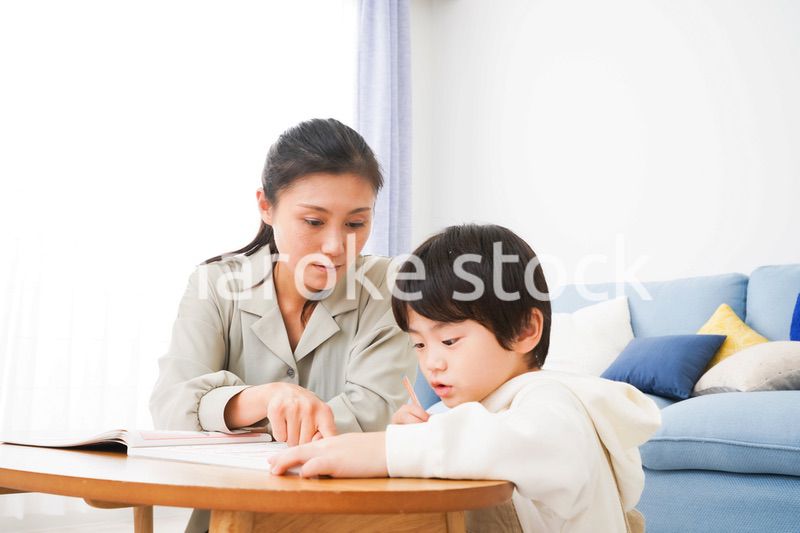 家でお母さんと一緒に勉強をする男の子