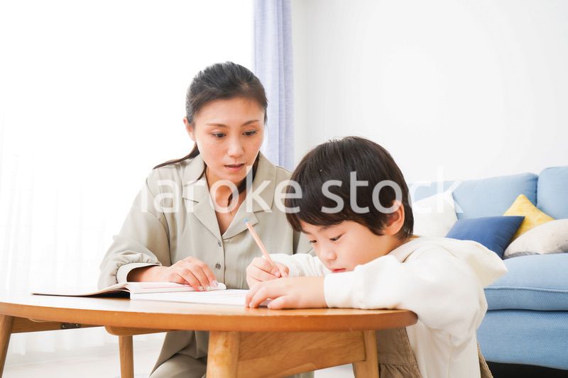 家でお母さんと一緒に勉強をする男の子