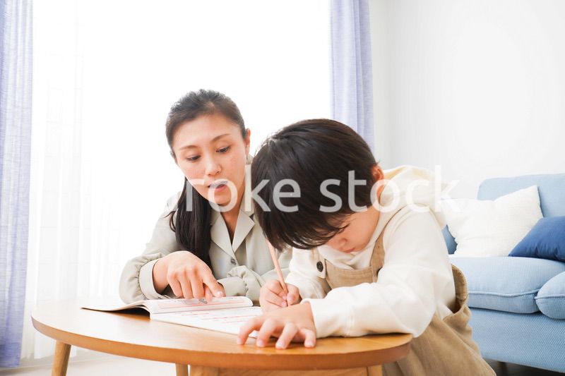 家でお母さんと一緒に勉強をする男の子