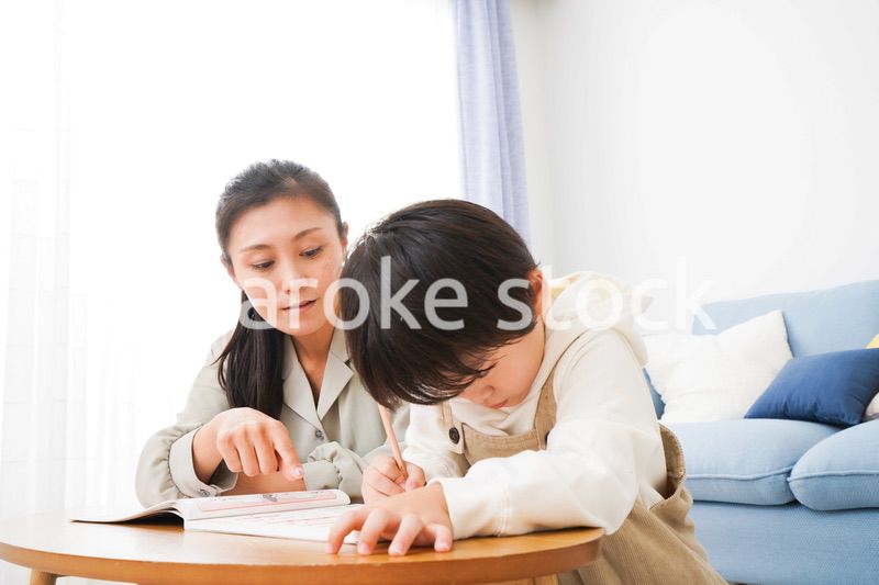家でお母さんと一緒に勉強をする男の子