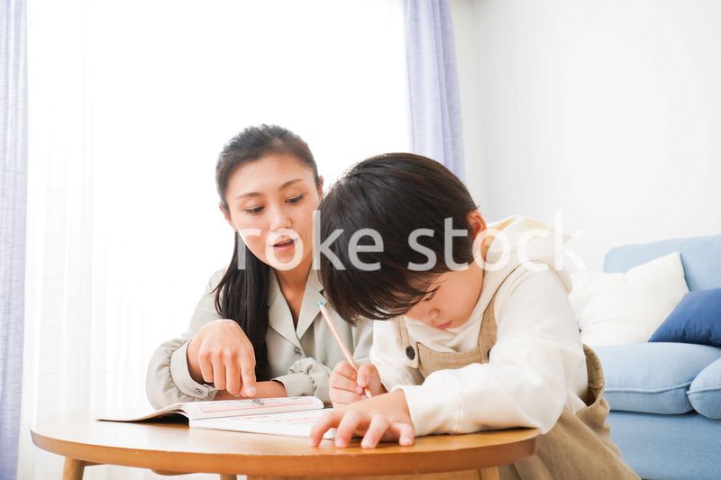 家でお母さんと一緒に勉強をする男の子