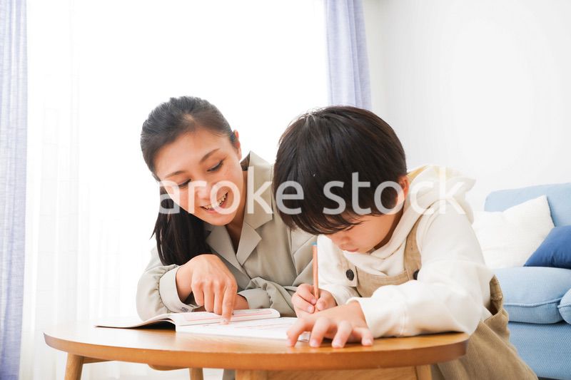 家でお母さんと一緒に勉強をする男の子