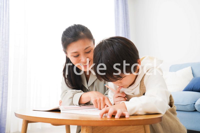 家でお母さんと一緒に勉強をする男の子