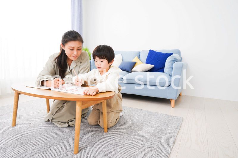 家でお母さんと一緒に勉強をする男の子