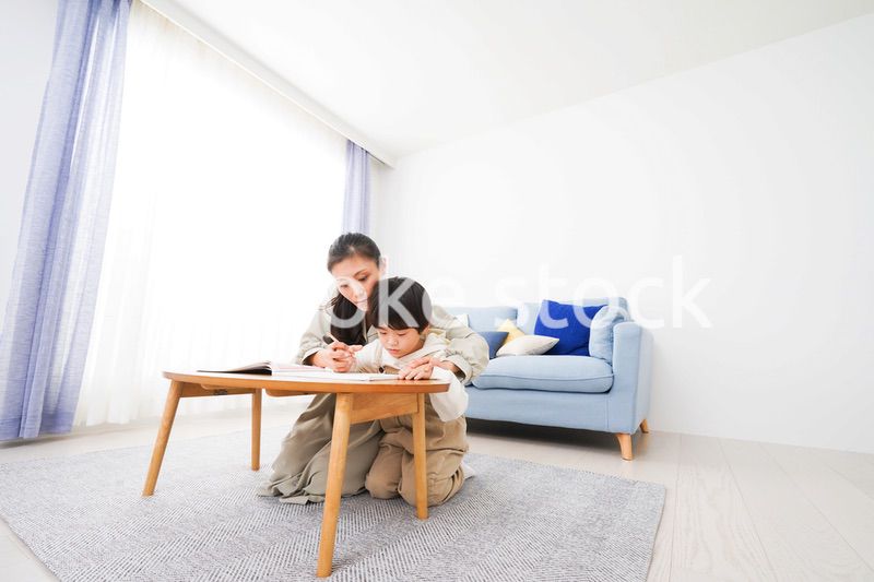 家でお母さんと一緒に勉強をする男の子