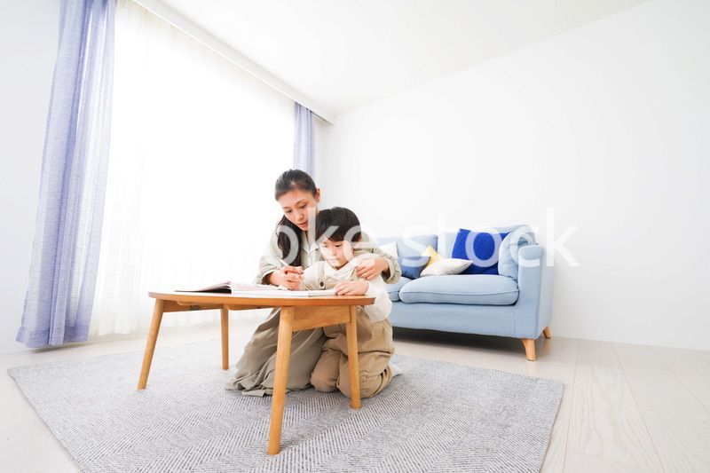 家でお母さんと一緒に勉強をする男の子