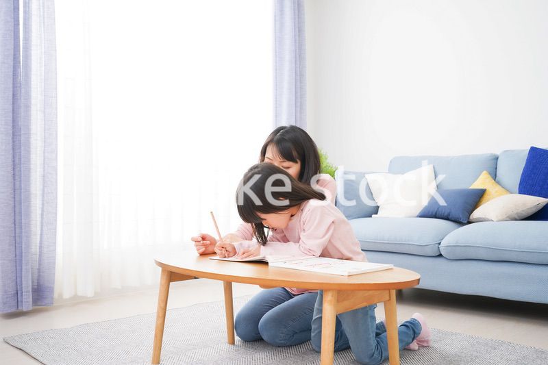 お家でお勉強をする女の子とお母さん