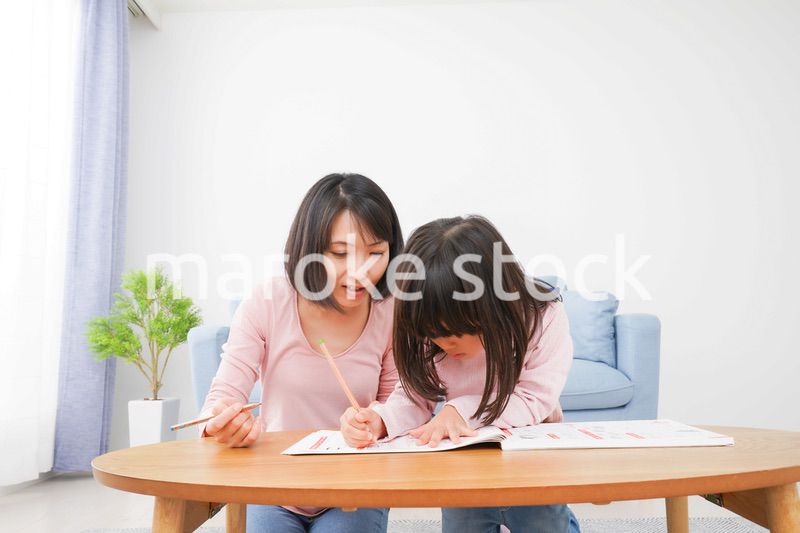 お家でお勉強をする女の子とお母さん
