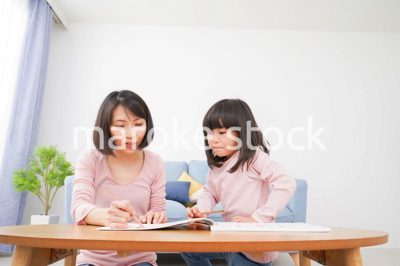 お家でお勉強をする女の子とお母さん