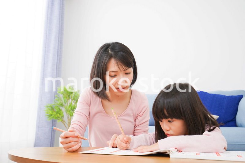 お家でお勉強をする女の子とお母さん