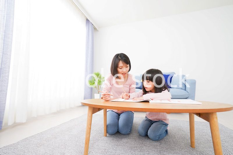 お家でお勉強をする女の子とお母さん