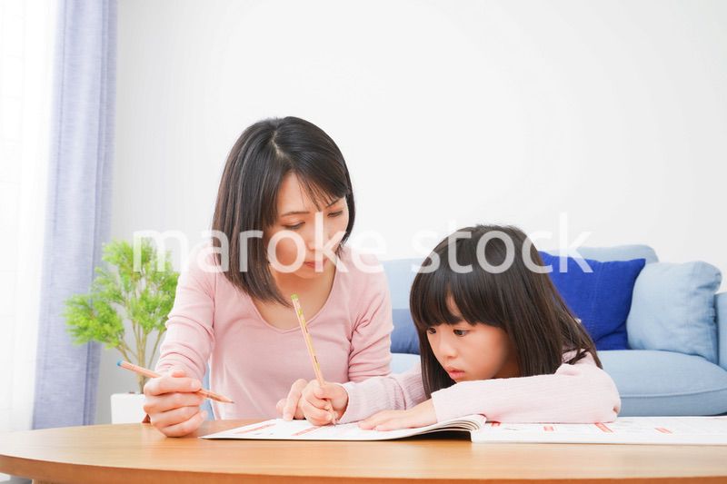 お家でお勉強をする女の子とお母さん