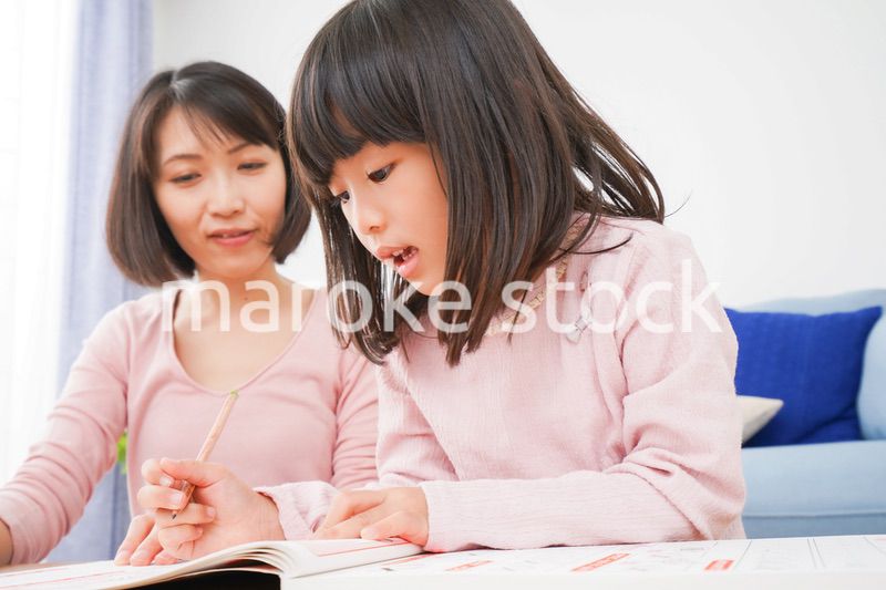 お家でお勉強をする女の子とお母さん
