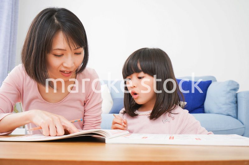 お家でお勉強をする女の子とお母さん
