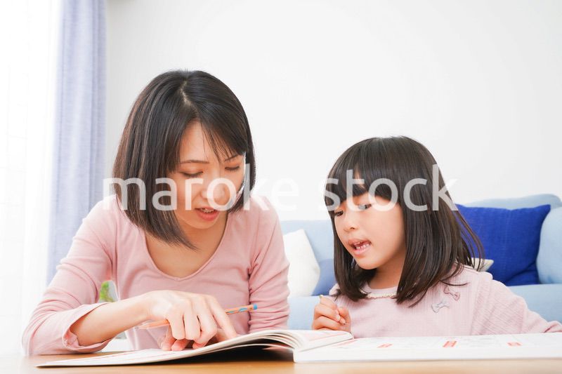 お家でお勉強をする女の子とお母さん