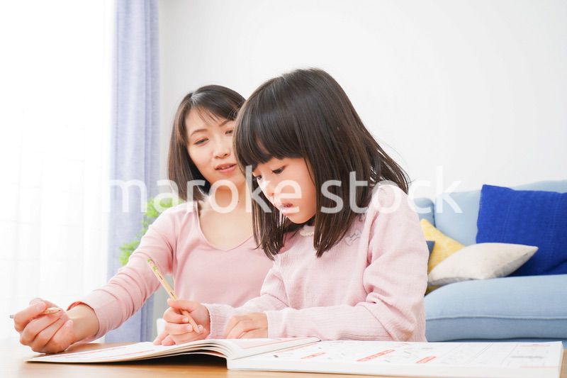 お家でお勉強をする女の子とお母さん