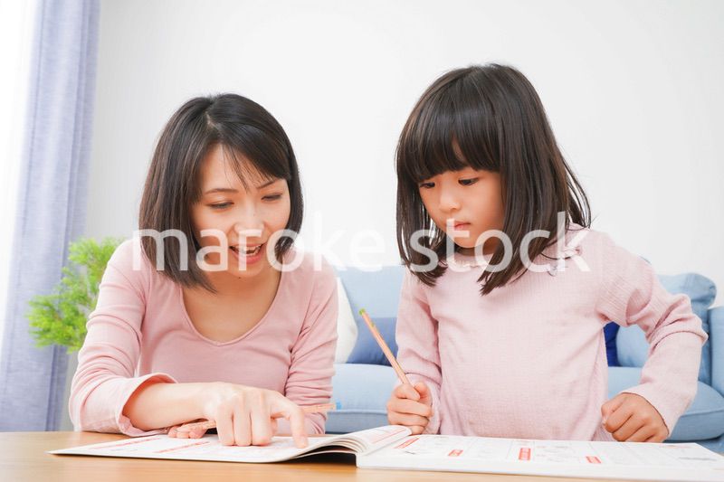 お家でお勉強をする女の子とお母さん